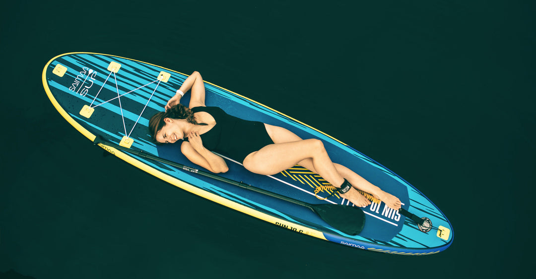 Nainen rentoutumassa Saimaa SUP Sun 10.6 -laudan päällä